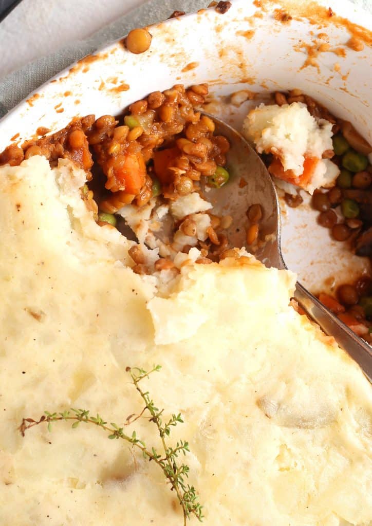 Finished dish in a large white casserole dish with a serving spoon