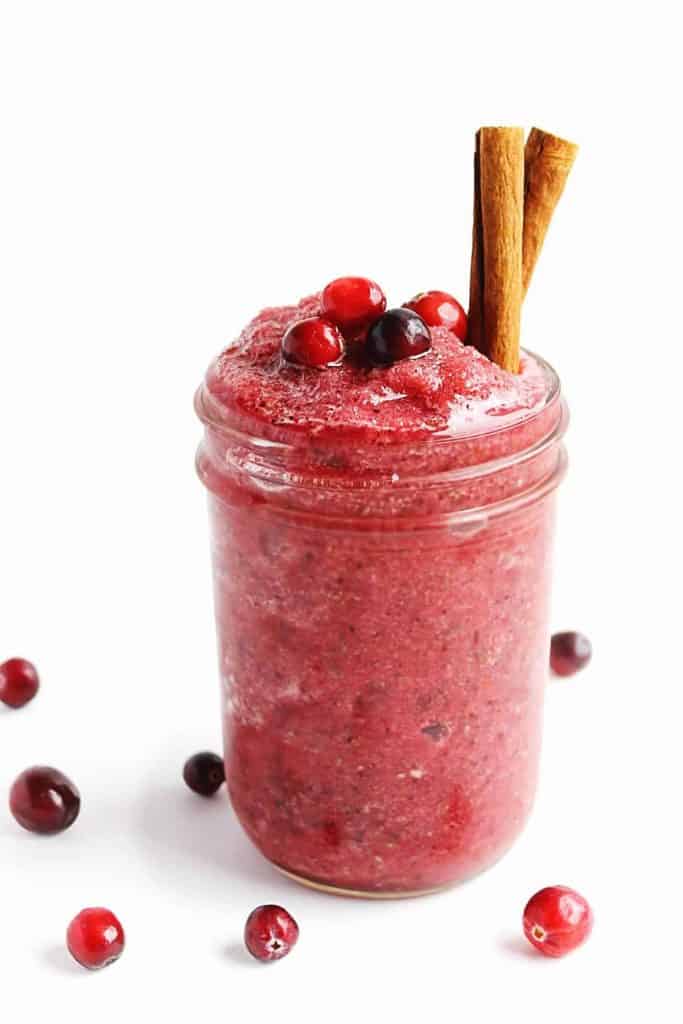 Cranberry smoothie in a mason jar with a white backddrop