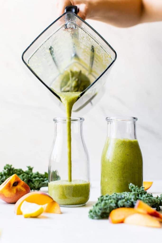 Kale smoothie poured into a glass from a blender
