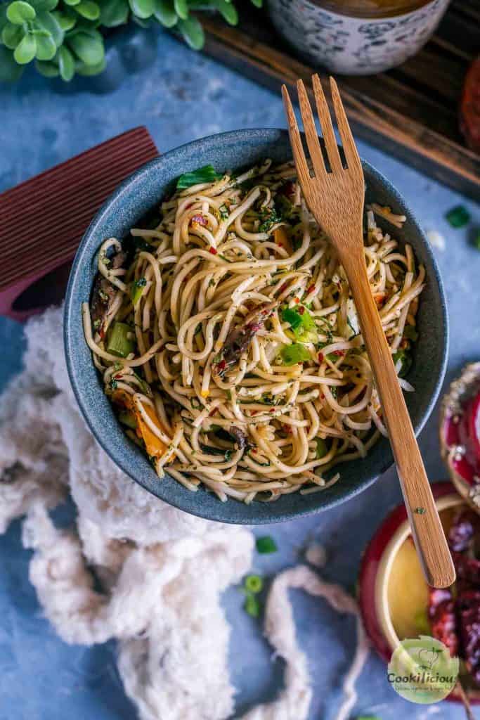 Cilantro Pot Noodles in a blue bowl with a wooden fork