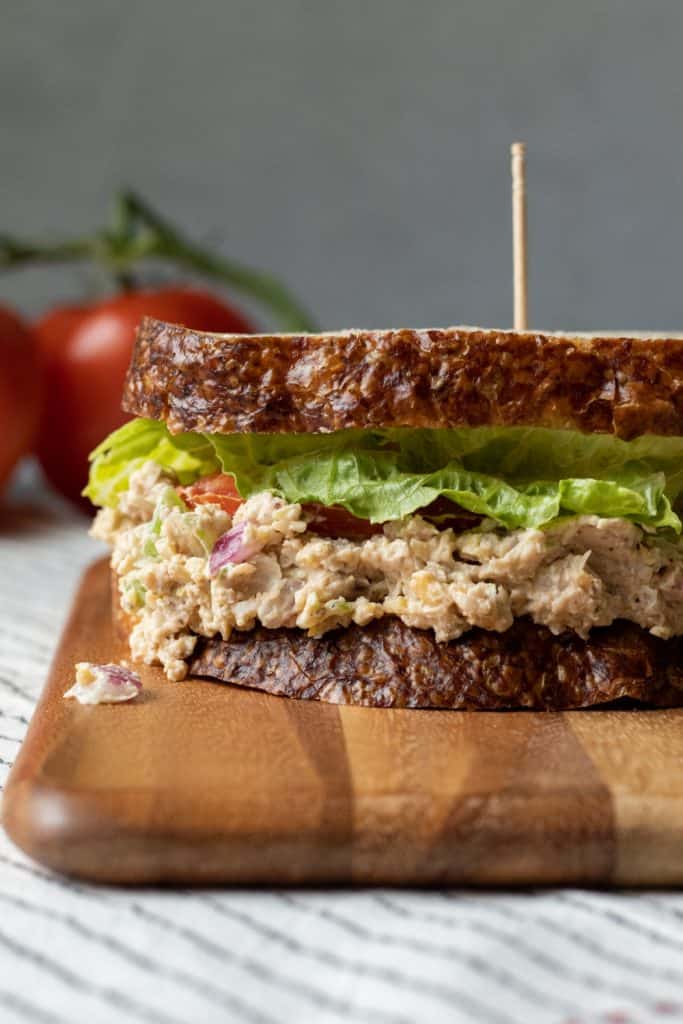 Close up of vegan tuna sandwich on a wooden cutting board