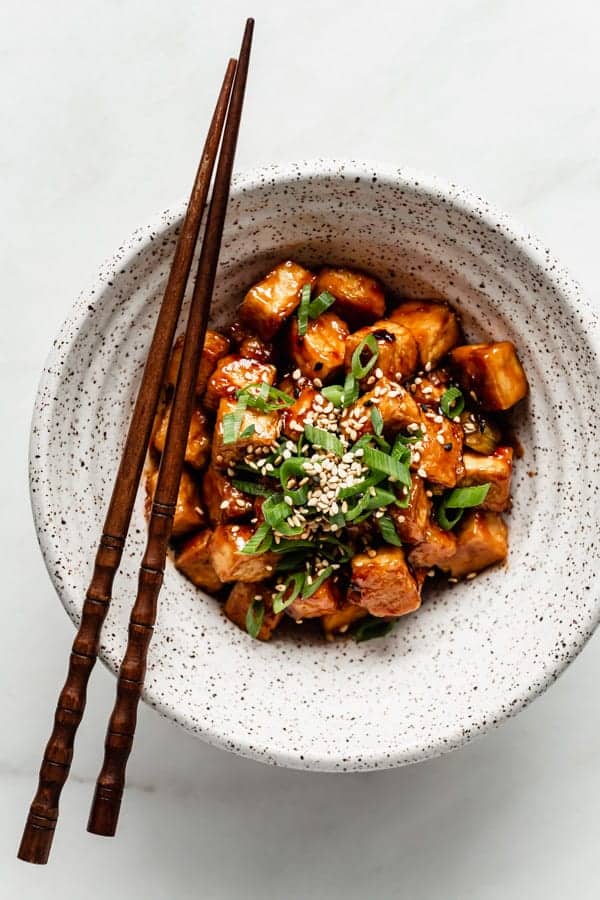 Bowl of General Tso Tofu with chopsticks