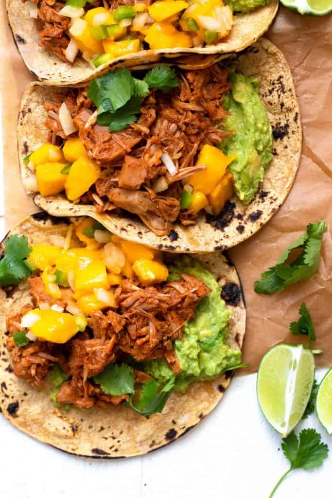 Jackfruit Carnitas tacos with mango salsa on corn tortillas with fresh lime and cilantro