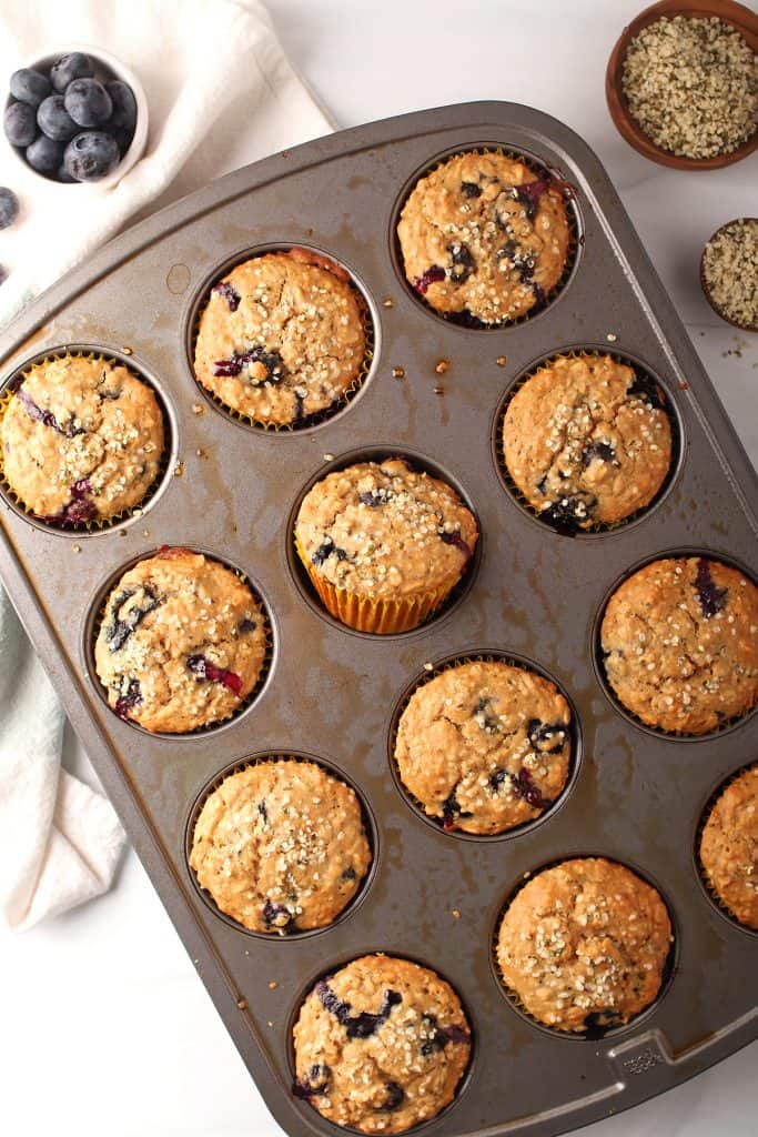 silver muffin tin with baked healthy blueberry hemp muffins