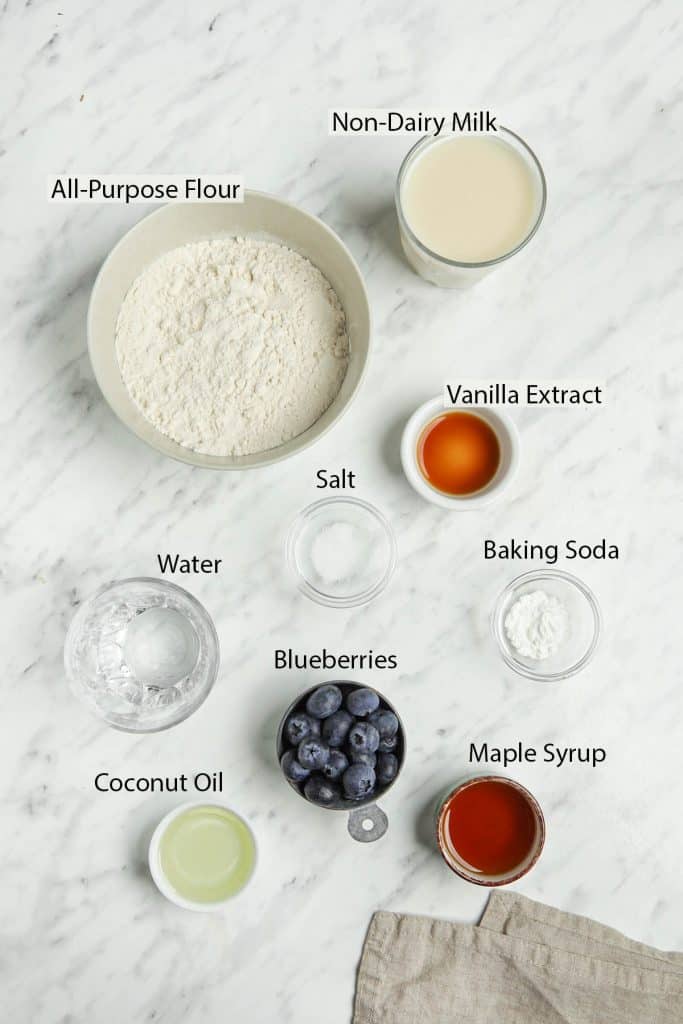 crepe pancake ingredients: all-purpose flour, salt, vanilla extract, baking soda, blueberries, maple syrup, coconut oil, non-dairy milk and water