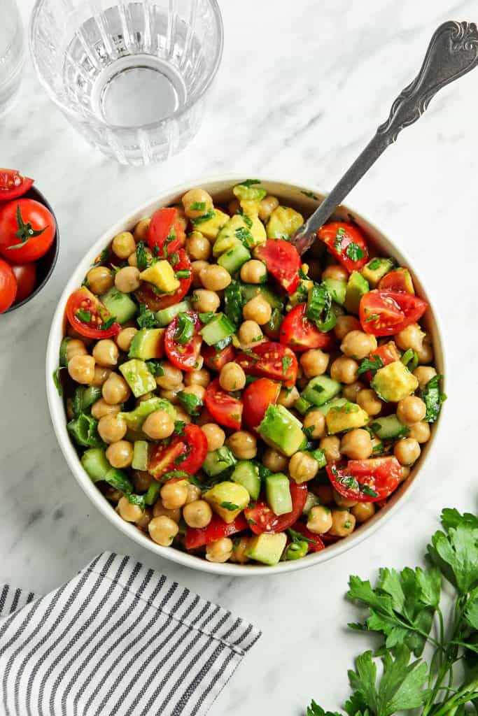 top view of Mediterranean chickpea salad in white bowl with spoon