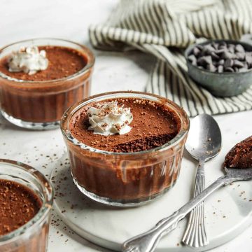 three glasses of vegan chocolate mousse with whipped cream