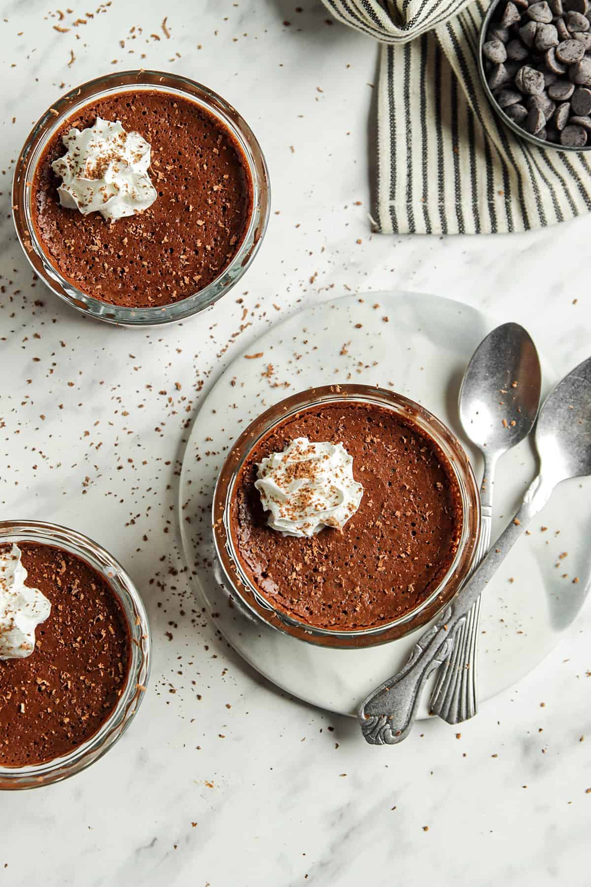 top view of three glasses filled with vegan chocolate mousse with spoons