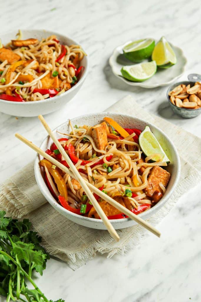 two bowls with vegan pad Thai noodles and chopsticks