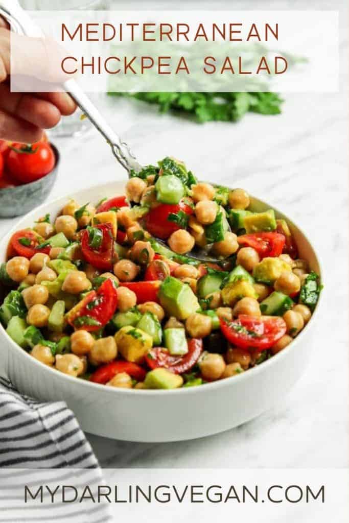 Greek chickpea salad in white bowl with spoon