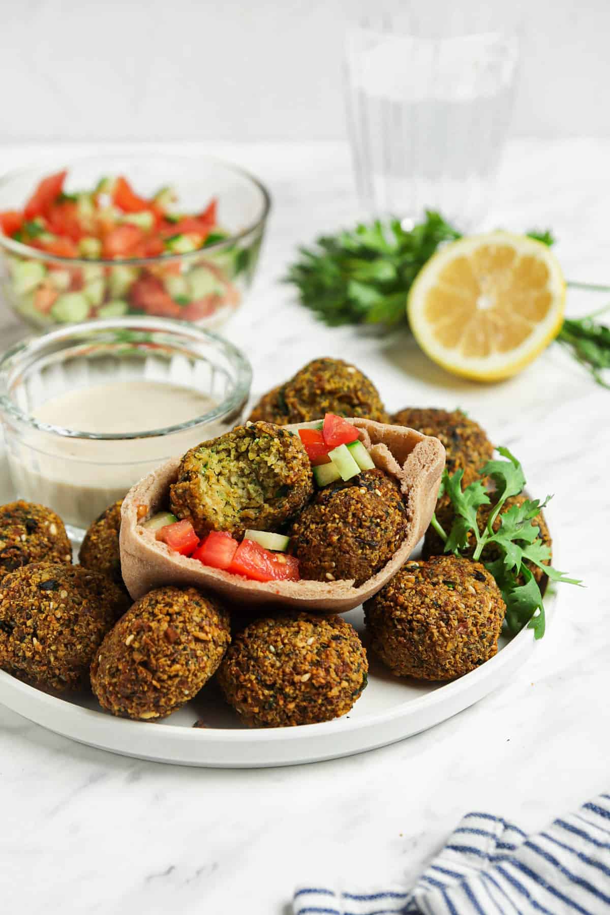 falafel in sandwich with pita, cucumbers, and tomatoes