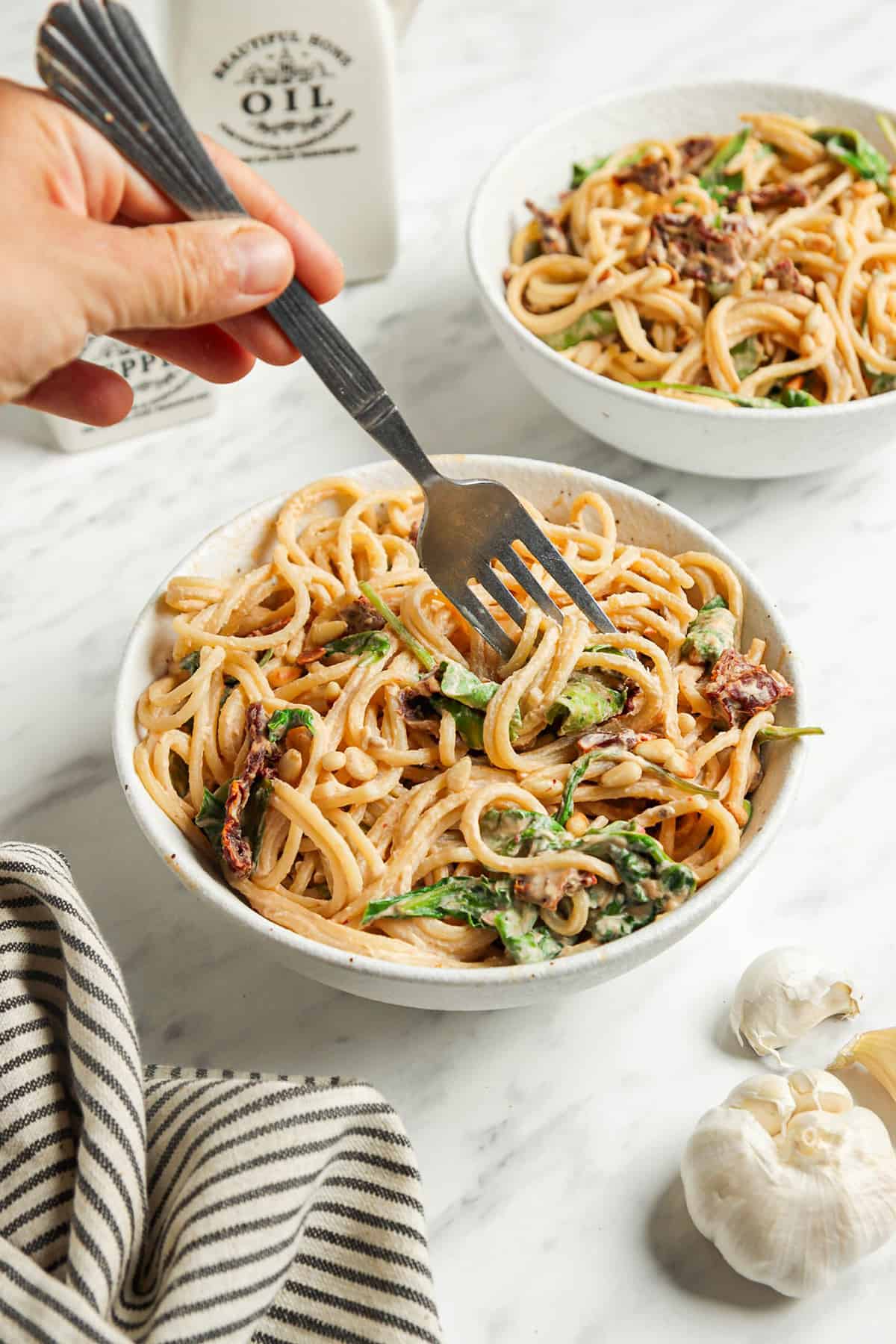 one bowl of hummus pasta with arugula and sun-dried tomatoes