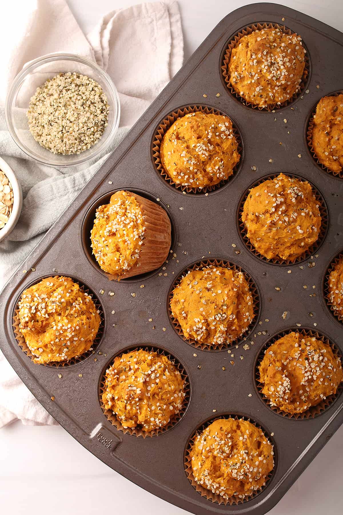 Silver muffin tin with baked healthy blueberry hemp muffins