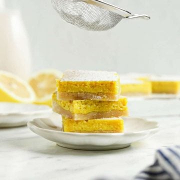 three lemon bars on top of each other with powdered sugar