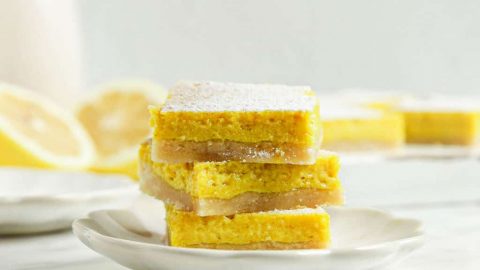three lemon bars on top of each other with powdered sugar