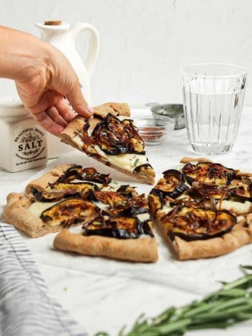 hand holding eggplant pizza slice