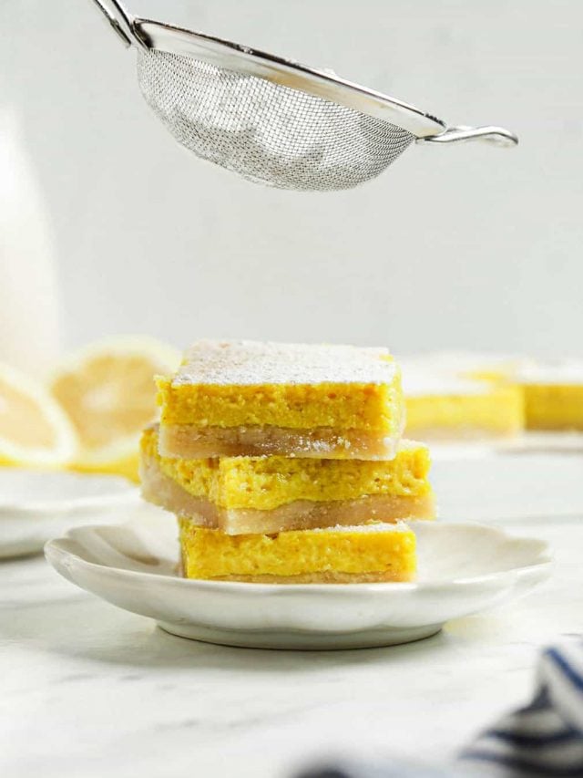 three lemon bars on top of each other with powdered sugar