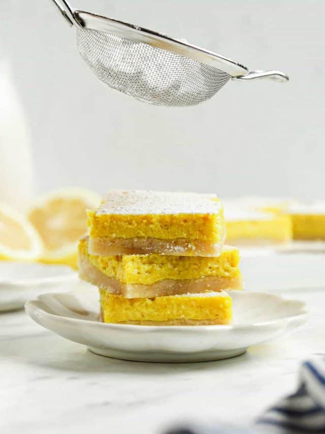 three lemon bars on top of each other with powdered sugar