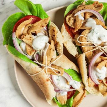 top view of two vegan gyros on plate with tzatziki sauce