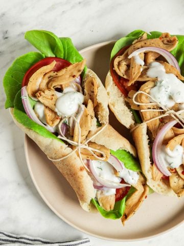 top view of two vegan gyros on plate with tzatziki sauce