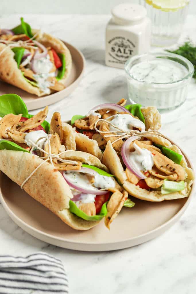 two vegan gyros with tzatziki sauce on plate