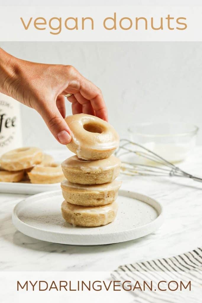 one stack of baked vegan donuts with hand holding donut