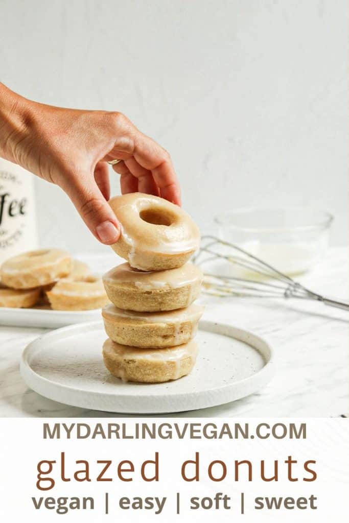 one stack of vegan donuts with hand holding donut. Pinterest text on bottom