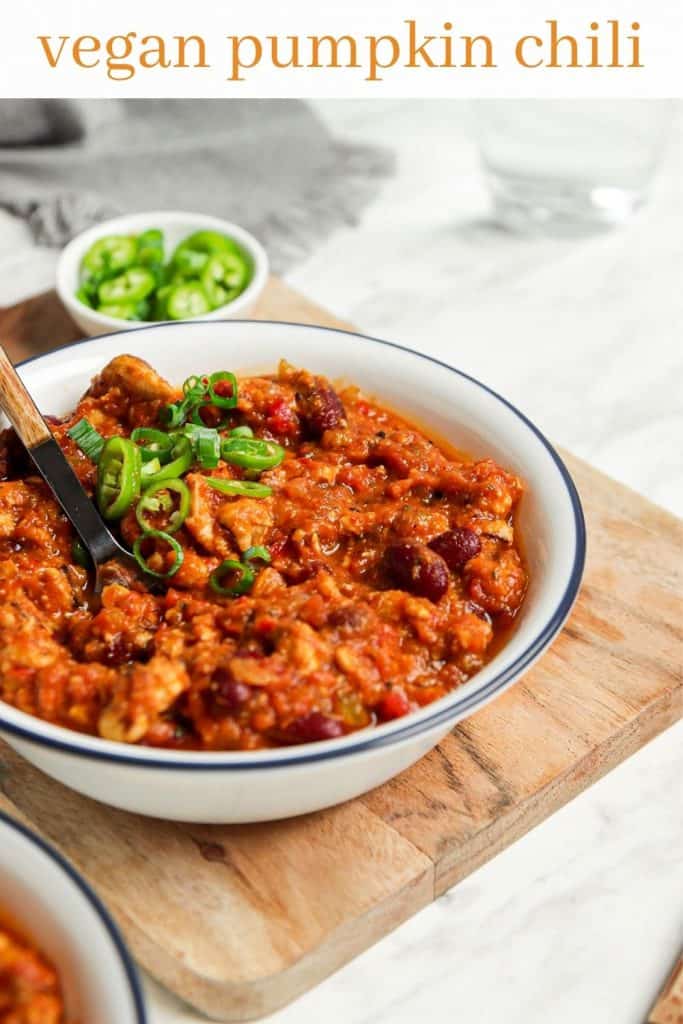 side view of vegan pumpkin chili with green onions and text above