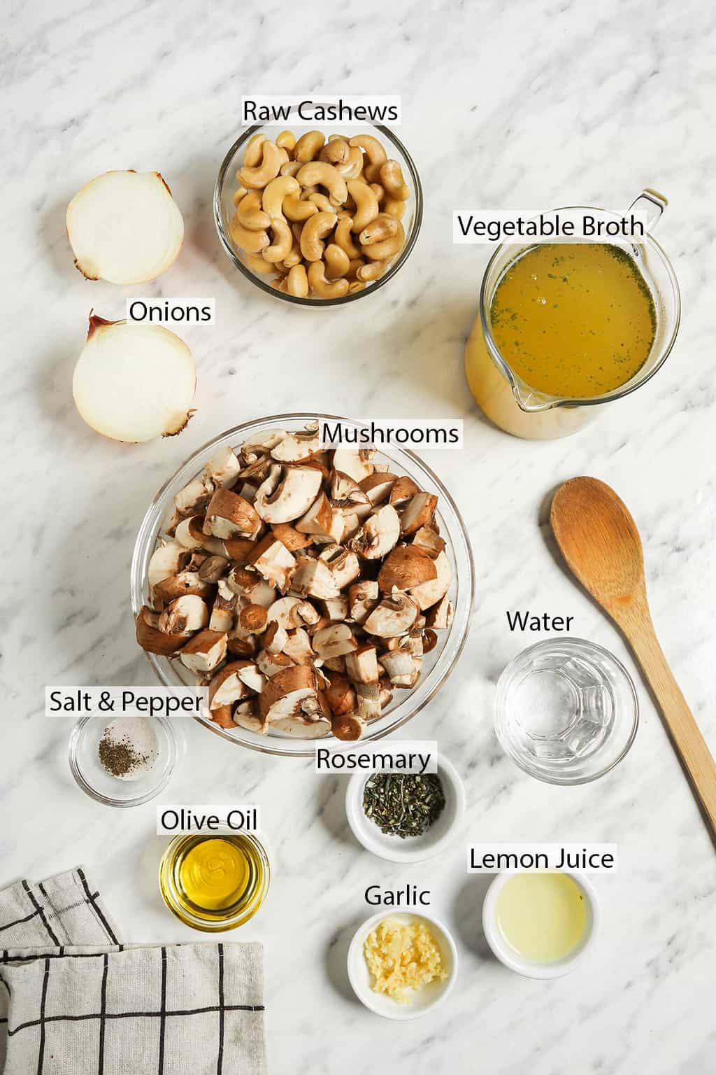 raw cashews, halved onion, vegetable broth, chopped mushroom, water, salt, pepper, olive oil, lemon juice, and rosemary in individual bowls for soup 