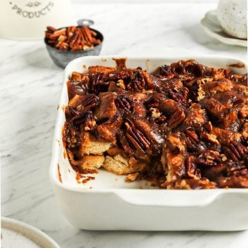 one pan of baked vegan bread pudding with slice taken out of it