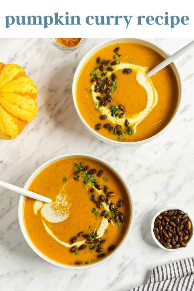 two bowls of pumpkin curry soup with toasted pumpkin seeds