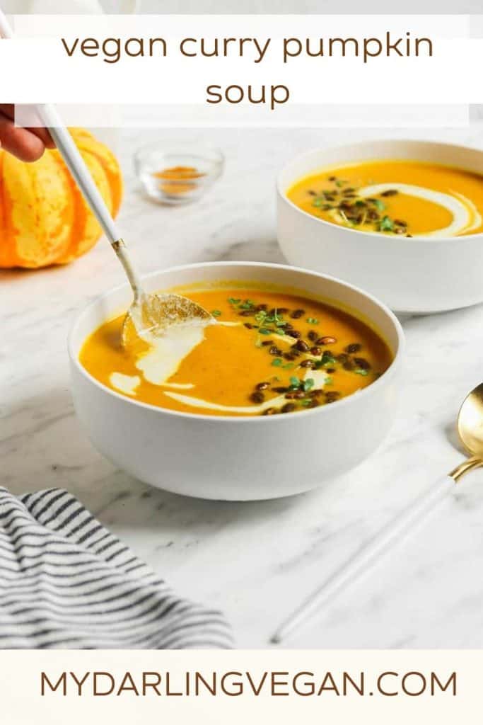 two bowls of pumpkin curry soup with pumpkin seeds