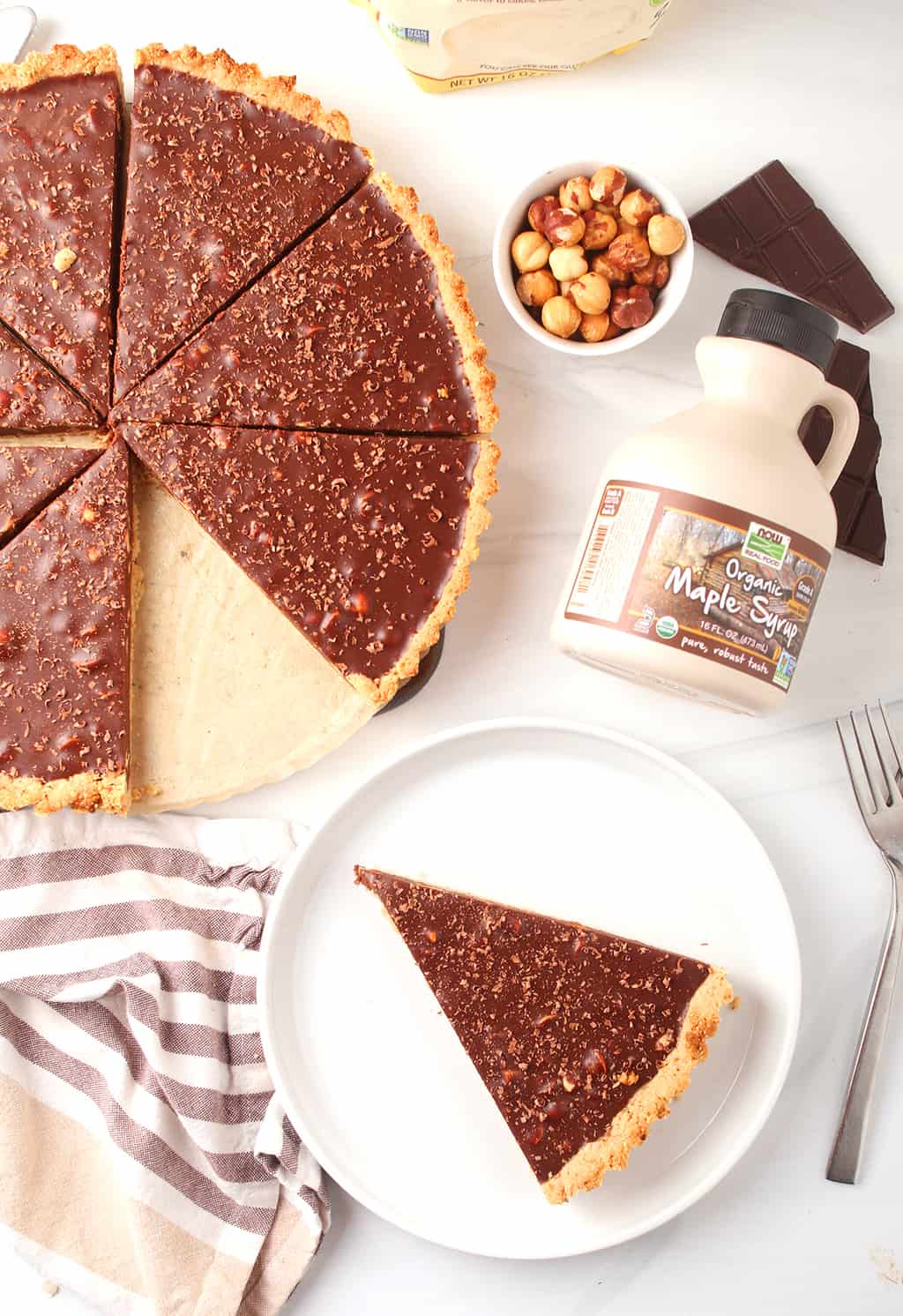 Overhead shot of piece of chocolate tart on a white plate