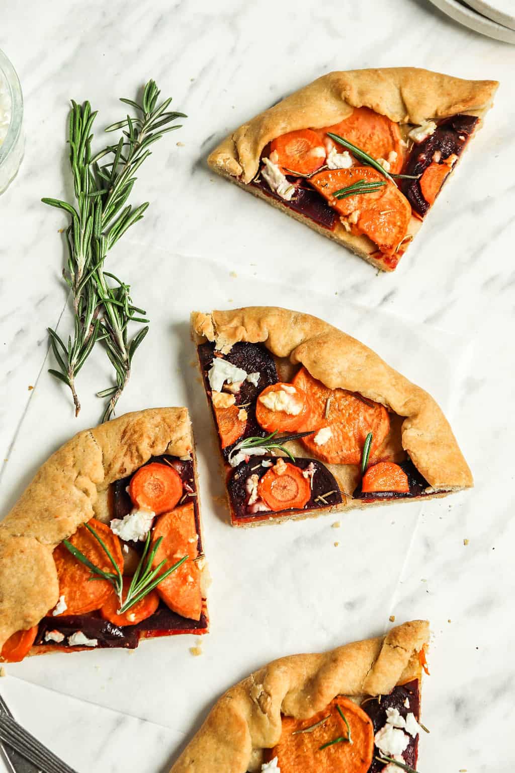 Slices of finished galette placed on a marble countertop. 