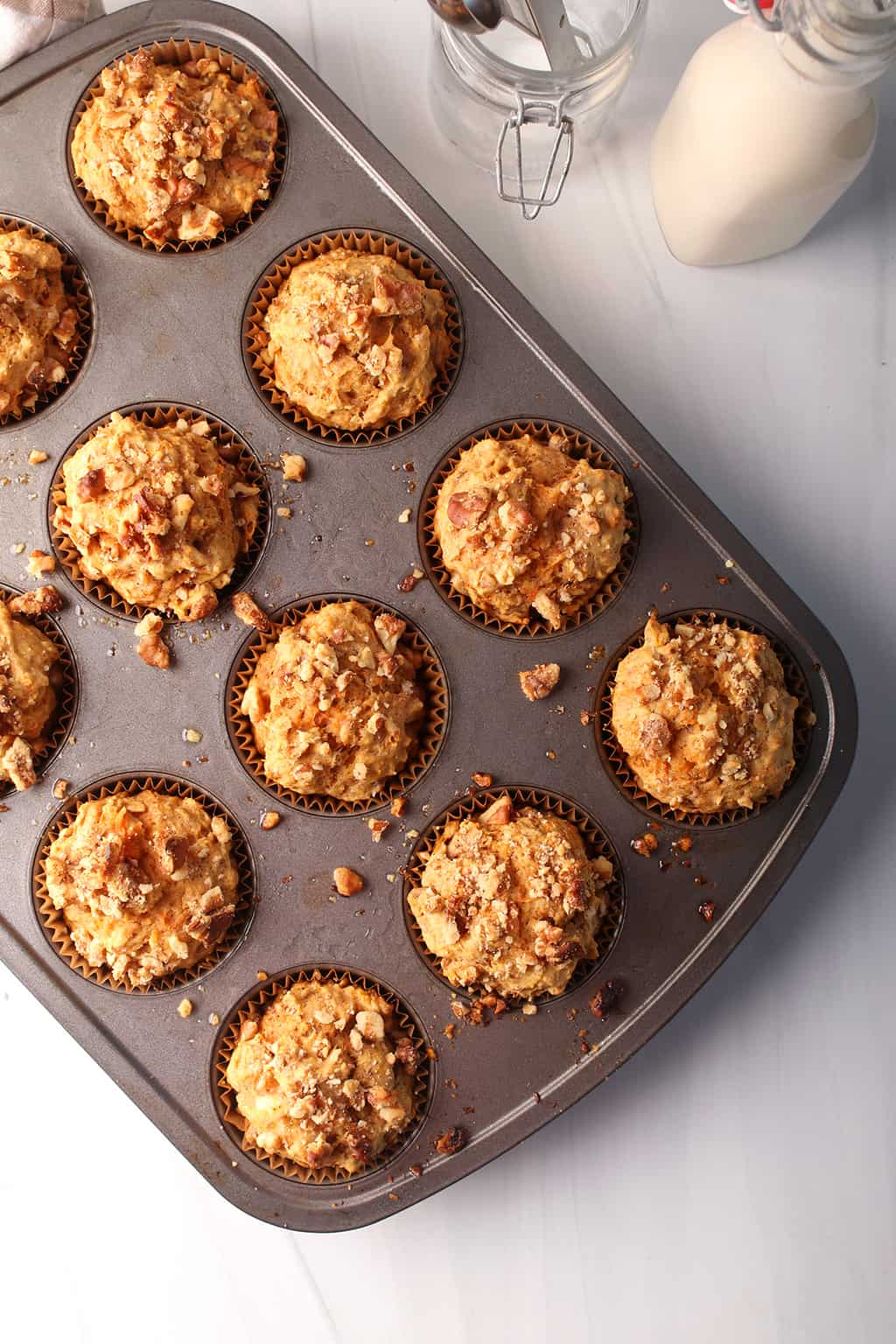 Finished muffins in the muffin pan on a white countertop. 