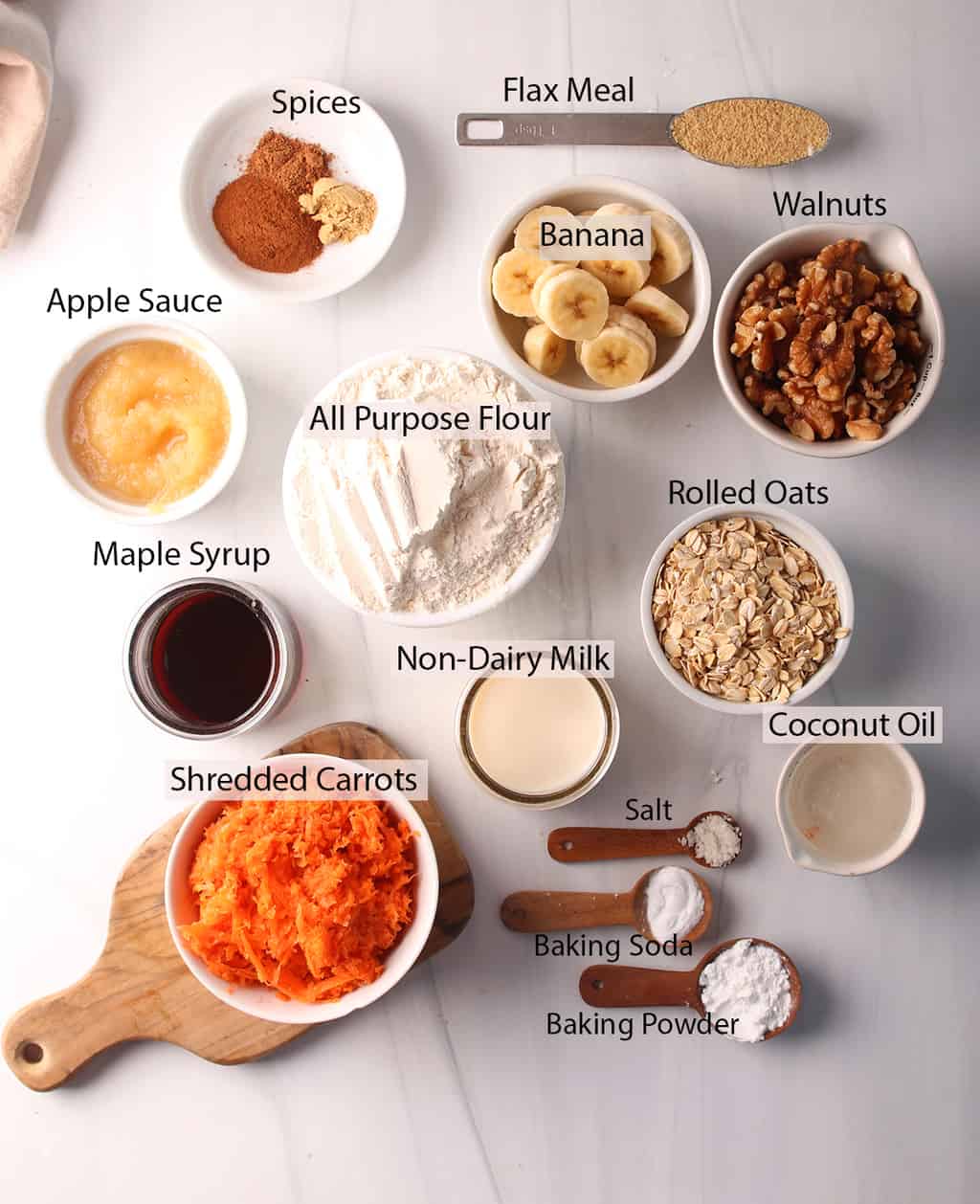 Ingredients for carrot muffins measured out and placed on marble countertop. 