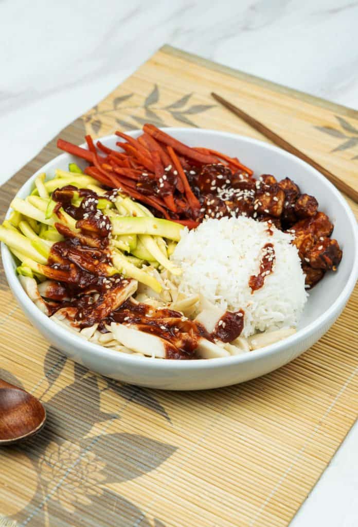 side view of yummy Vegan bibimbap bowl with marinated tofu over rice