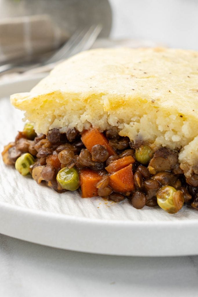 Close side view of vegan shepherds pie with creamy mashed potatoes and hearty lentil filling