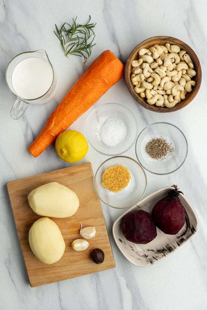 all the ingredients for dairy-free vegetable gratin on a white marble counter