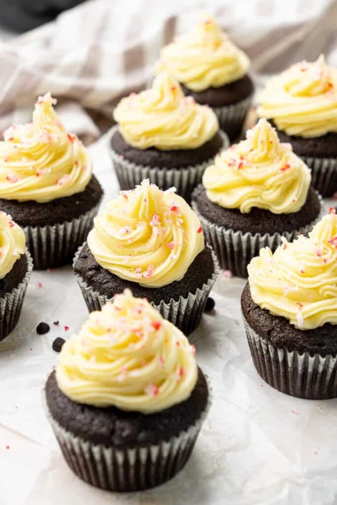 rows of vegan chocolate peppermint cupcakes topped with creamy frosting and crushed candy canes