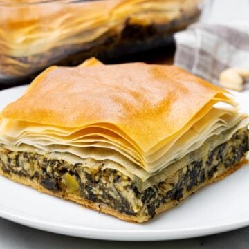 side view of vegan spanakopita with cashew feta, flaky phyllo and thick spinach filling