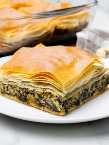 side view of vegan spanakopita with cashew feta, flaky phyllo and thick spinach filling