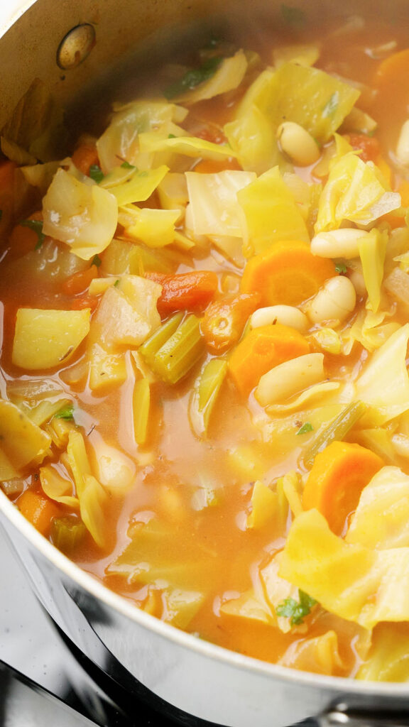 vegan cabbage soup simmering in a pot building delicious flavors
