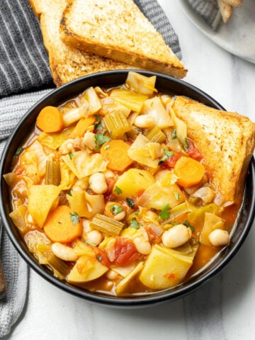top view of Vegan cabbage soup with potatoes and white beans in a bowl