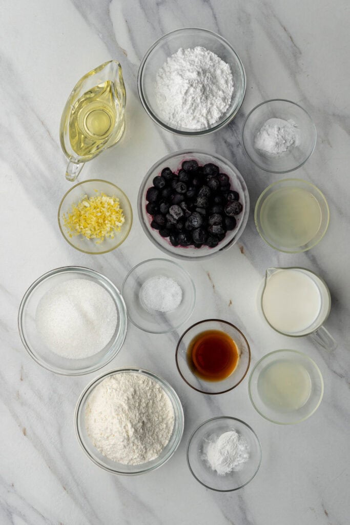 ingredients for vegan lemon blueberry loaf measured and arranged including flour, sugar, and plant milk