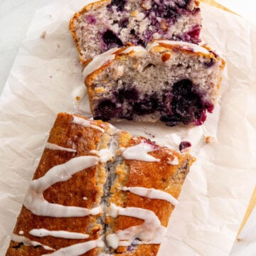 Lemon blueberry loaf with vegan glaze drizzle sliced and arranged showing golden top and moist interior