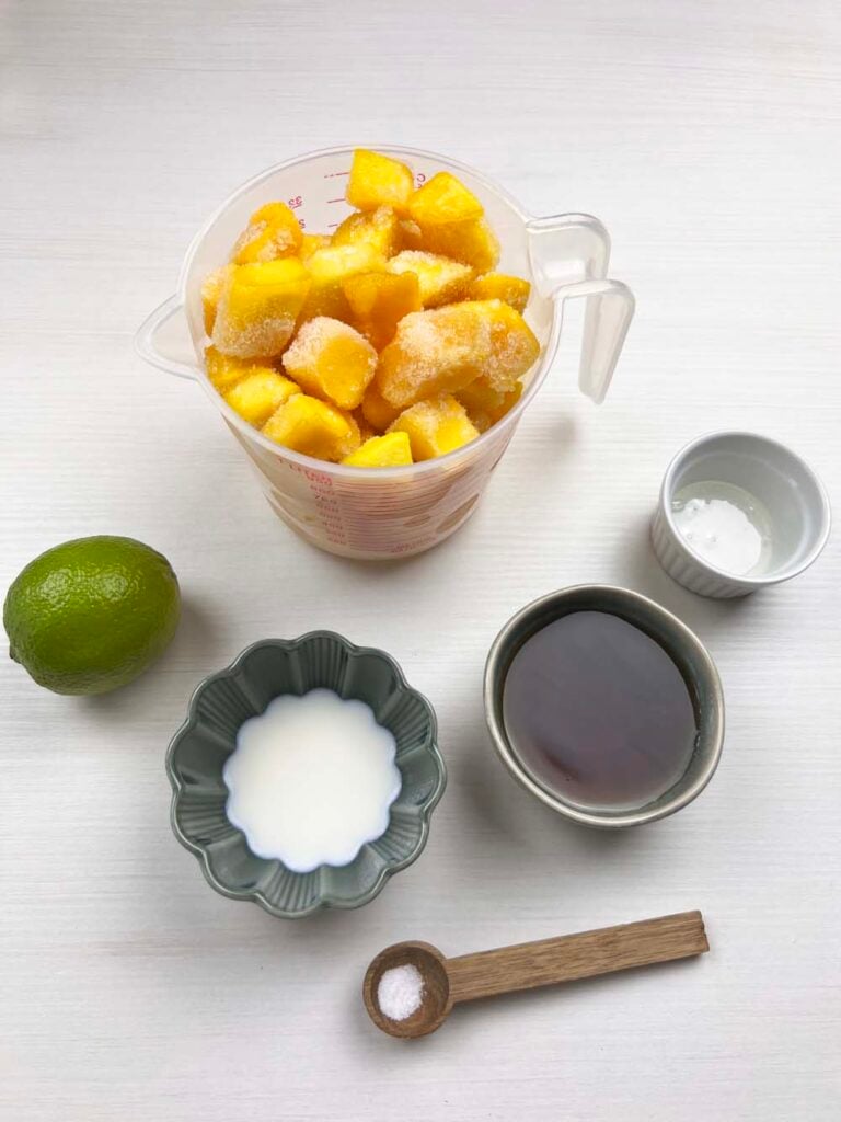 Mango, lime, sugar, vegan cream, and syrup - ingredients for dairy-free mango sorbet