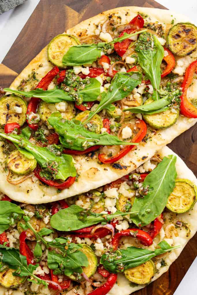 grilled vegetable chimichurri flatbread topped with zucchini, red bell peppers, dairy-free feta and arugula