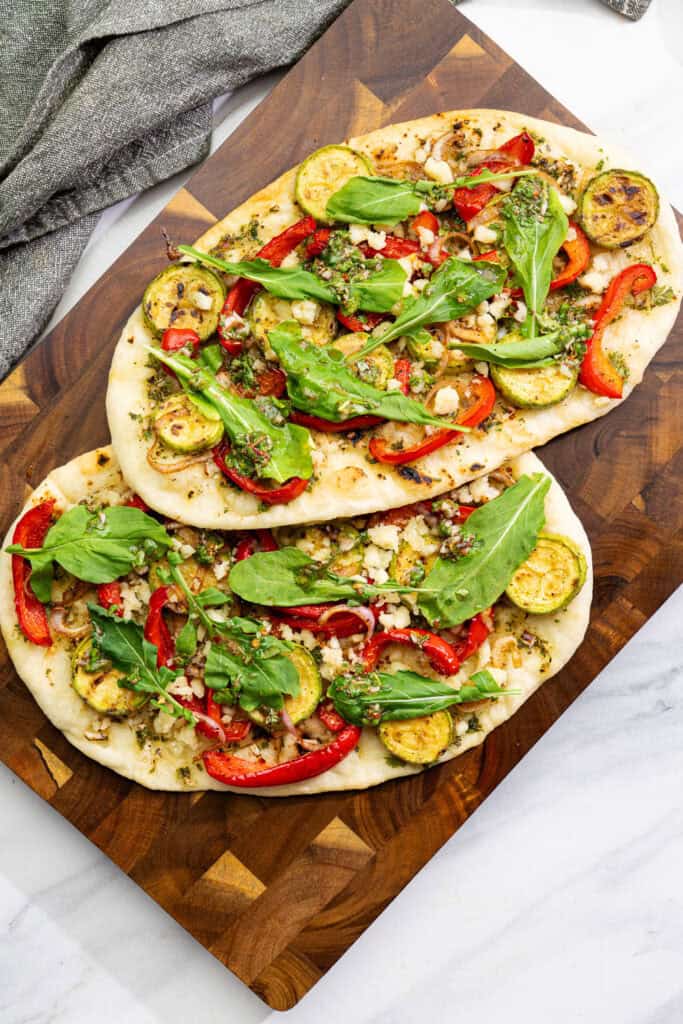 whole vegan flatbreads topped with grilled vegetables and fresh homemade chimichurri sauce