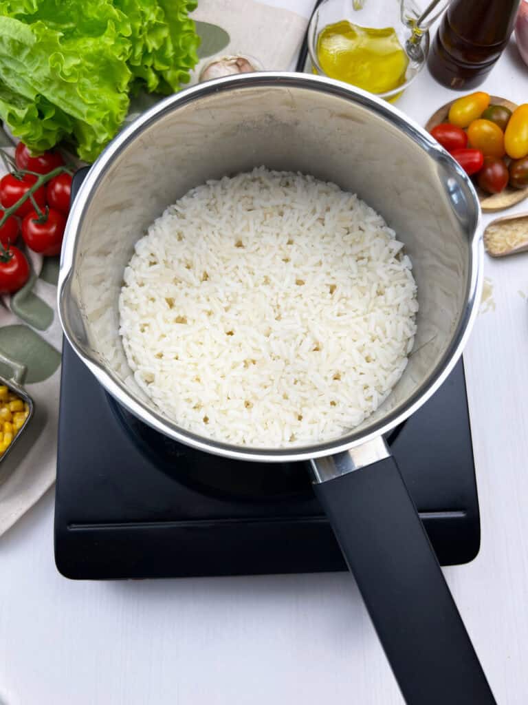 Cooking jasmine rice in a small pot for vegan corn bowls aka elote